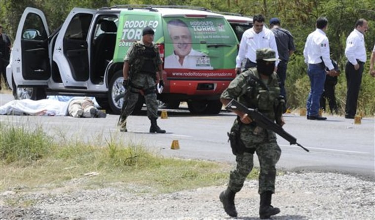 Army soldiers guard the crime scene after candidate for governor of the state of Tamaulipas, Rodolfo Torre, was ambushed by unidentified gunmen near Ciudad Victoria, Mexico, Monday. Gunmen assassinated the front-running candidate and several of his aides in what Mexico's President Felipe Calderon called an attempt by drug gangs to sway local and state elections this weekend.